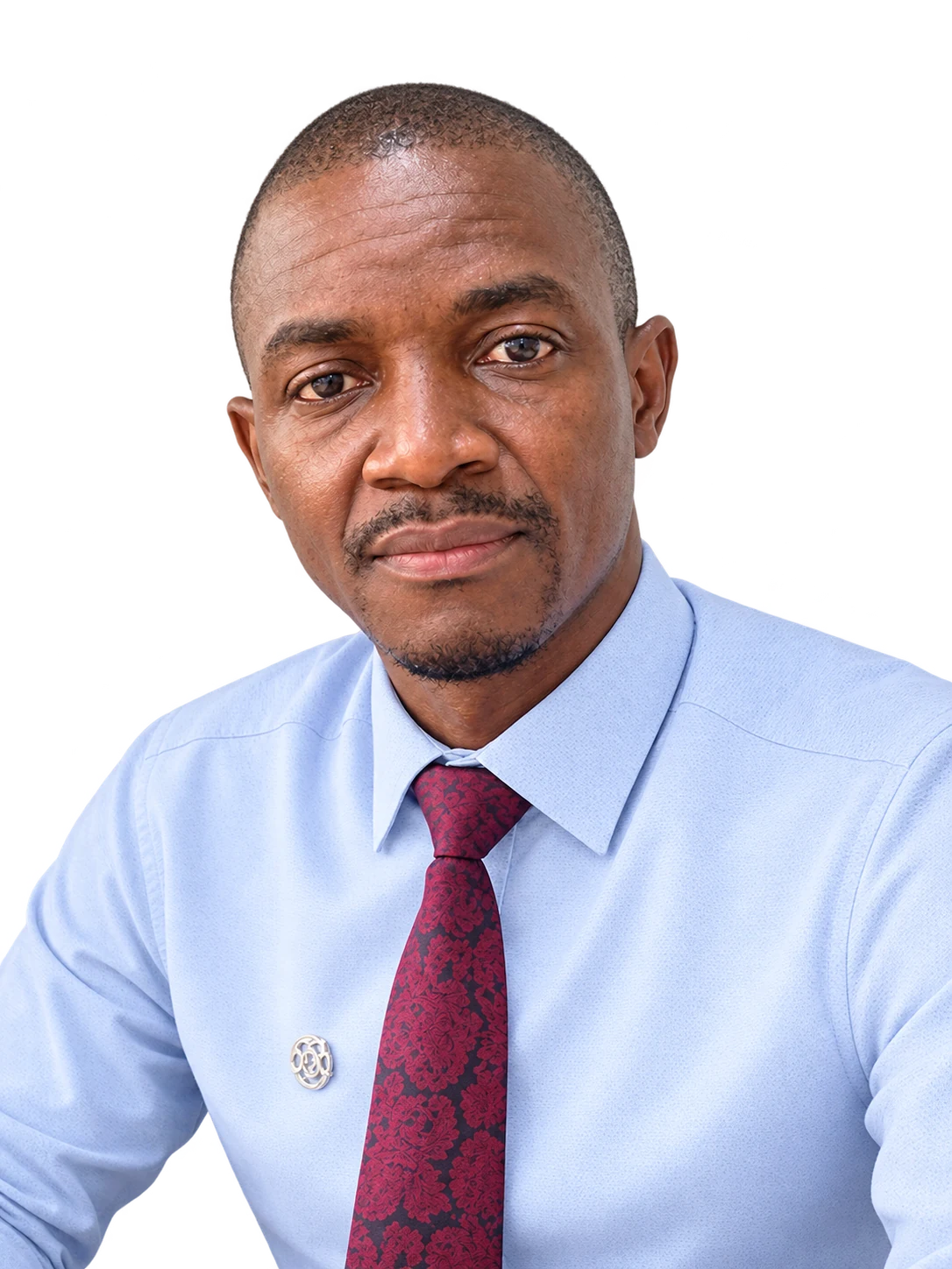 Hon. Clarence Namunyu Kasali, aspiring Member of Parliament for Ikolomani, in a light blue shirt and patterned maroon tie